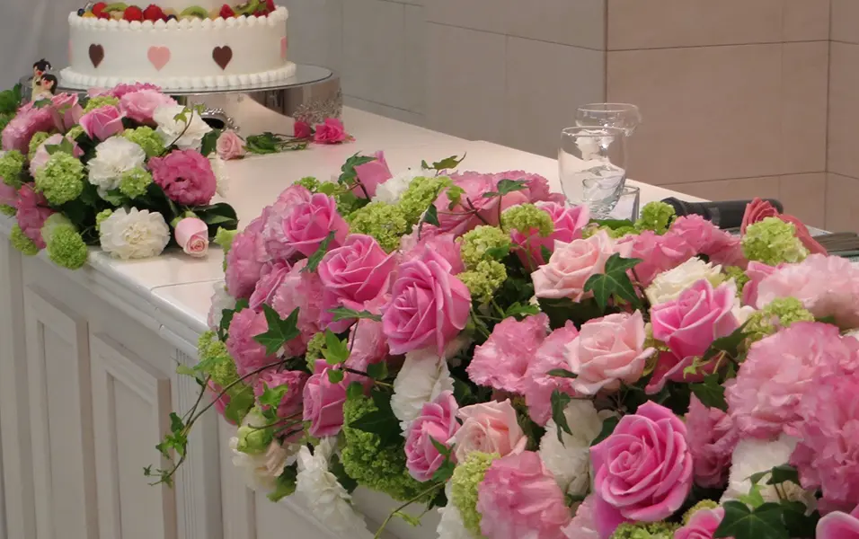 ピンクの花々で彩ったウェディングケーキ周りの装花