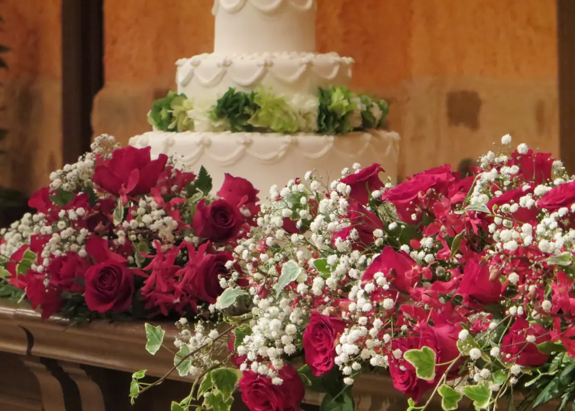 レッドとボルドーの花々を使ったウェディングケーキ周りの装花