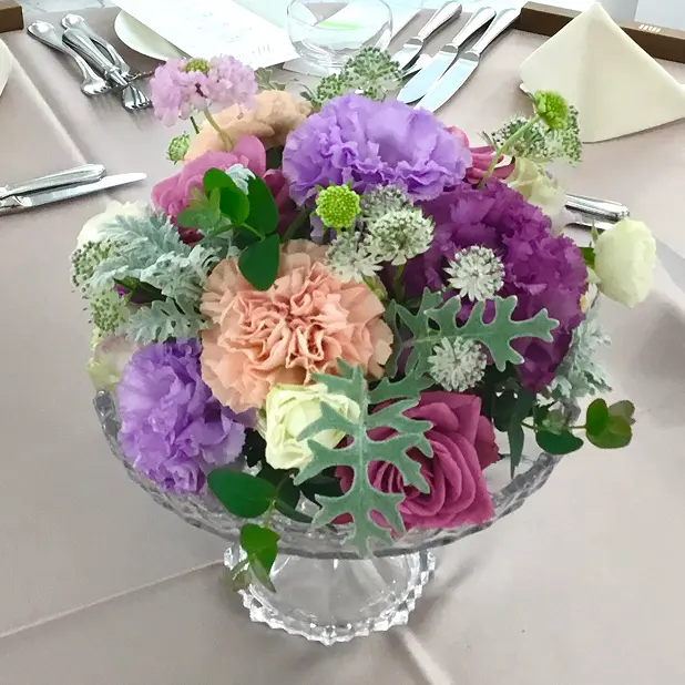 ラベンダーモーヴを基調に色とりどりの花を合わせたゲストテーブル装花