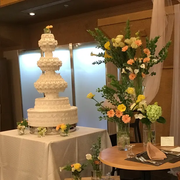 イエローとオレンジを取り入れたウエディングケーキ装花