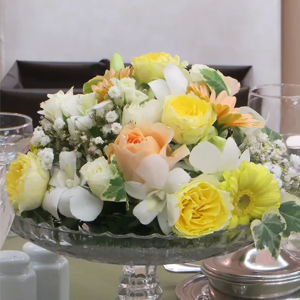 イエローとホワイトのラウンドテーブル装花